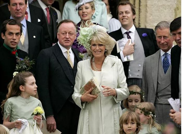 Камилла стоит между своим бывшим мужем Эндрю Паркером Боулзом и королем Чарльзом на свадьбе дочери в 2006 году.