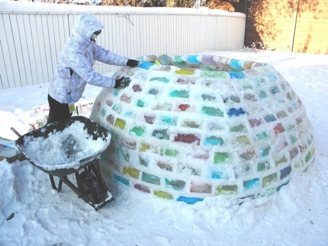 Процесс строительства хижины иглу из разноцветных ледяных *кирпичей*