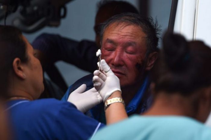 Ся Бойю оказывают медицинскую помощь после успешного восхождения 14 мая 2018 года.