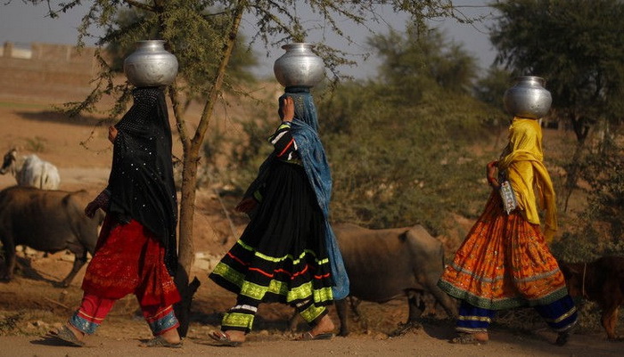Женщины преодолевают путь в несколько километров по пустыне с алюминиевыми чанами на голове