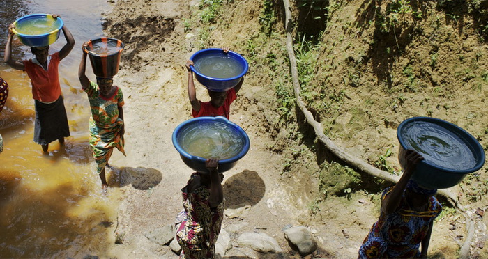 Женщины носят мутную воду из реки