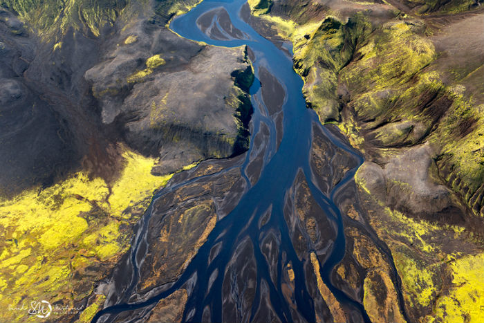 Бесчисленные реки, подобно змеям, извиваются между скалистыми утёсами и ярко-зелёными равнинами