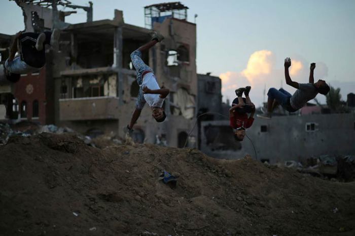 Подростки практикуются в паркуре посреди разрушенного войной Газа.