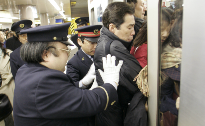 Оshiya заталкивает людей в вагон. | Фото: farmilly.com.