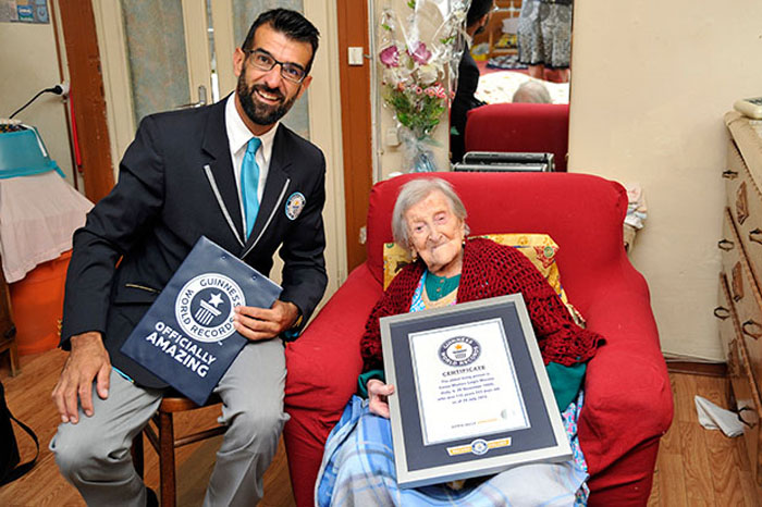 Представитель Guinness World Records вручает Эмме Морано сертификат о рекорде.