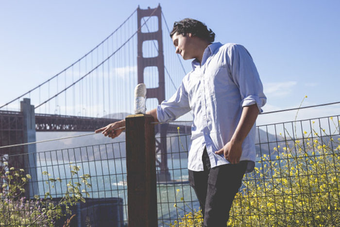 Счастливая пара позирует в центре Сан Франциско на фоне  Golden Gate Bridge.