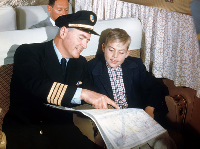 Пилот общается с мальчиком в салоне самолета.