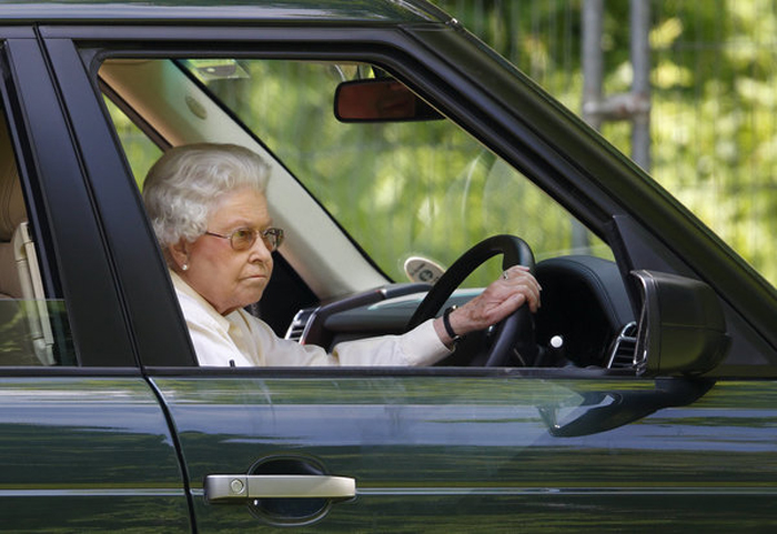 Елизавета Вторая наблюдает из своего автомобиля за гонками гран-при, проходящими в Виндзоре.