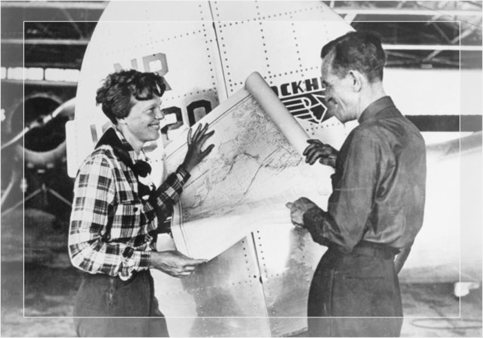 Пилот Амелия Эрхарт и её штурман Фред Нунан с картой Тихого океана, на которой указан запланированный маршрут их последнего полёта. 