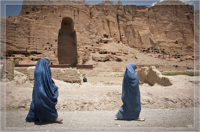 Две женщины проходят мимо огромной пустоты, где раньше стоял один из древних Будд Бамиана.