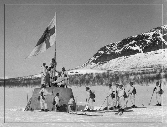 Финские солдаты поднимают флаг на границе между Норвегией, Швецией и Финляндией после окончания Второй мировой войны.