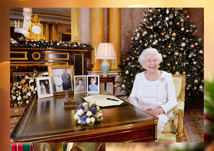 Королева Елизавета II сидит за столом в Букингемском дворце после записи своей рождественской речи. 