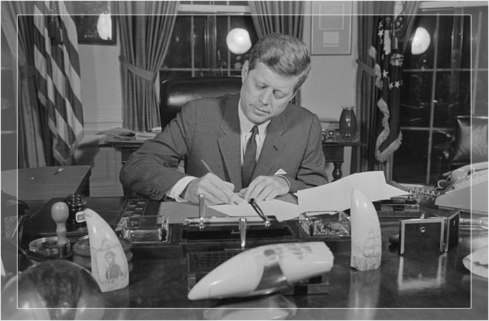 Президент Джон Ф. Кеннеди подписывает прокламацию, официально вводящую в действие карантин оружия США против Кубы во время кубинского ракетного кризиса. 