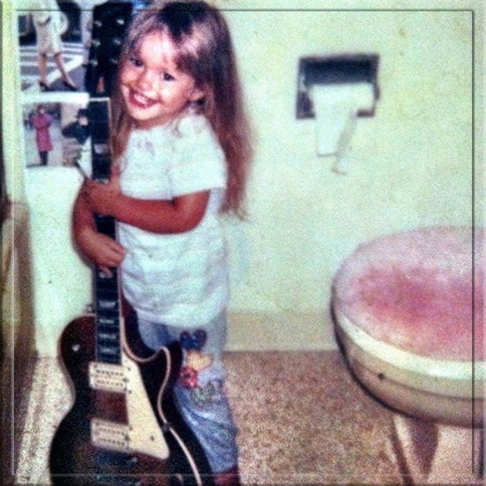 Минка Келли в детстве с гитарой отца.
