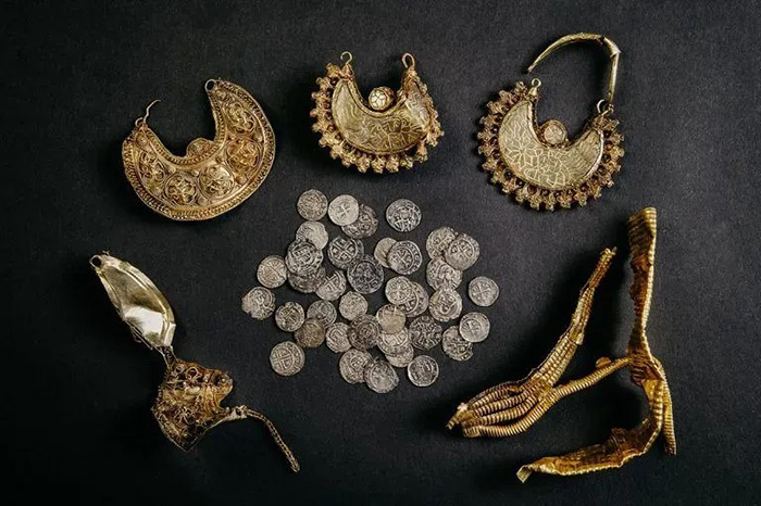 Тайник с серебряными монетами и золотыми серьгами, обнаруженный металлоискателем в Нидерландах. / Фото: Fleur Schinning