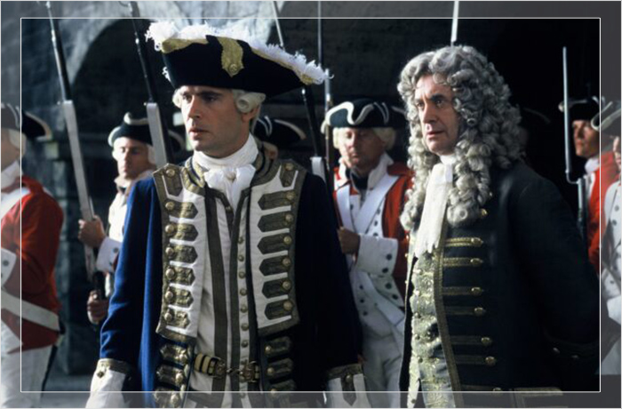 Джонатан Прайс в роли Уэзерби Суонна и Джек Дэвенпорт в роли Джеймса Норрингтона, оба в напудренных париках в рекламном кадре для «Пиратов Карибского моря».