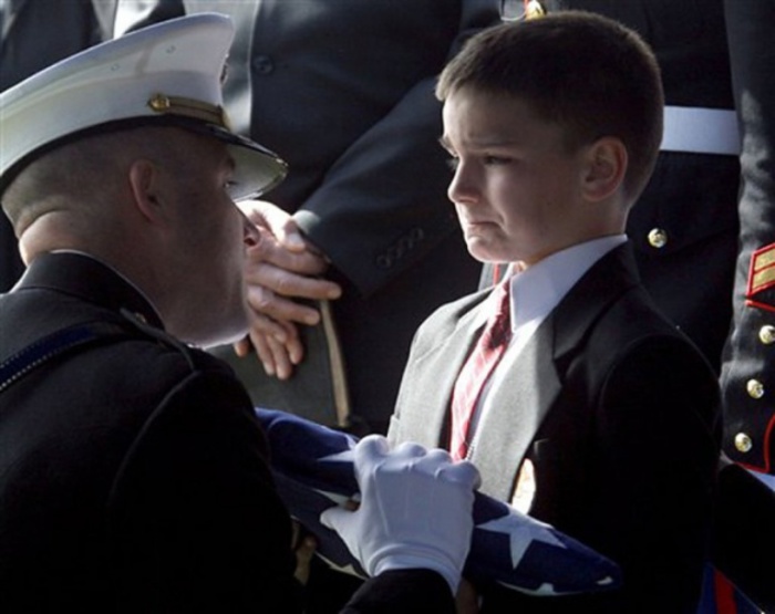  8-летний  Кристиан принимает флаг во время поминальной службы по его отцу. Который был убит в Ираке всего за несколько недель до того, как он был должен возвратиться домой.