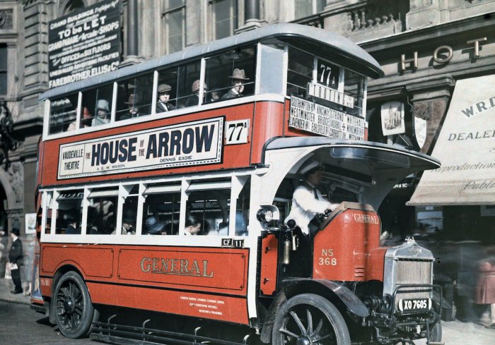 Двухэтажный лондонский автобус подбирает пассажира.