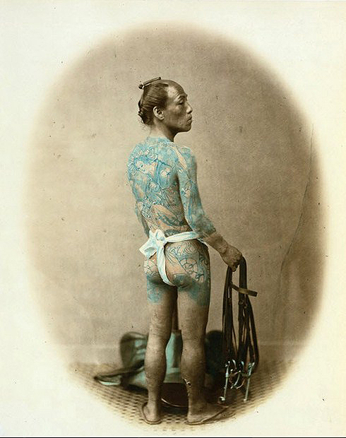 Самурай, тело которого покрыто религиозными и мифологическими татуировками.  Цветные фотографии Японии 1865 года. Автор фото: Felice Beato.
