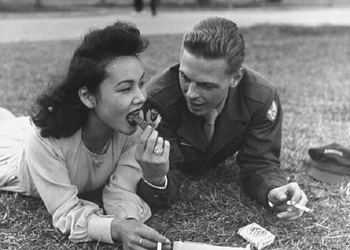 Американский солдат и местная девушка обмениваются шоколадкой и сигаретой.