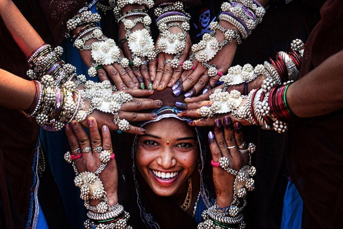 Жительницы индийского штата Гуджарат в традиционных серебряных украшениях благословляют девушку, которая только что вышла замуж. Категория «Улыбка». Фотограф Sanghamitra Sarkar.