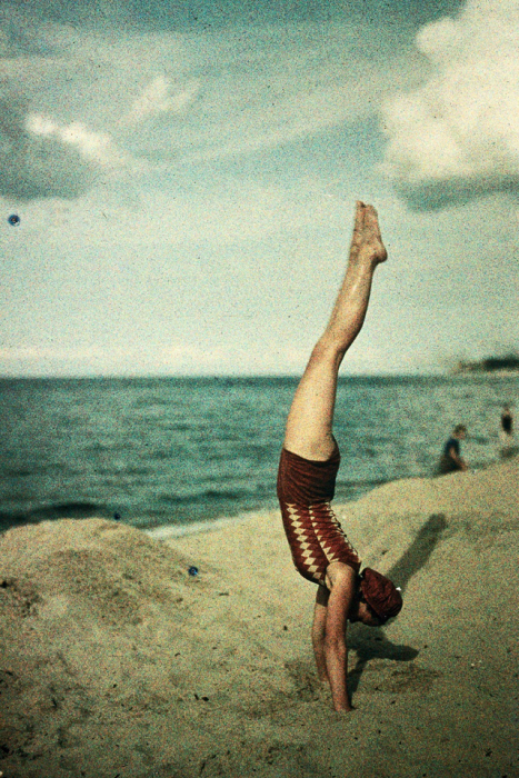 Акробатические трюки девушки на пляже.