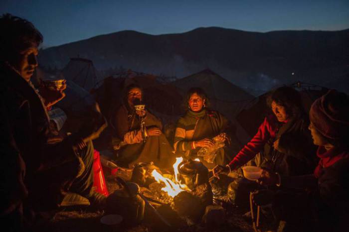 Тибетские буддийские кочевники готовят еду и греются у огня вечером после пений в честь ежегодного собрания Счастья Дхармы, в Буддийском институте Larung Wuming в Сертар, Ганьцзы, Тибетский автономный округ, провинция Сычуань.