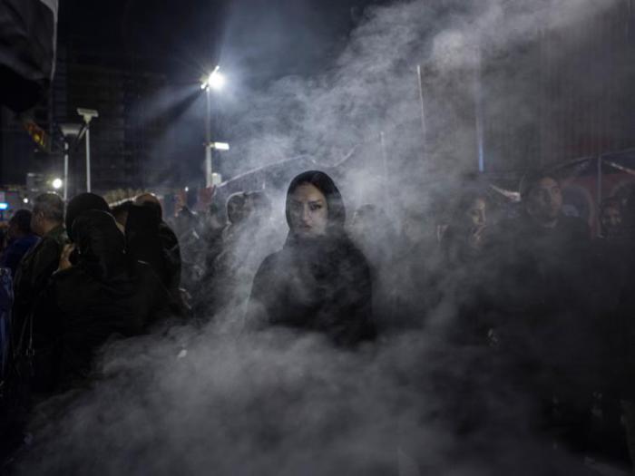 Иранская женщина выходит из дыма, вызванного сжиганием трав могильника. Согласно народным поверьям, ритуал защищает от сглаза.