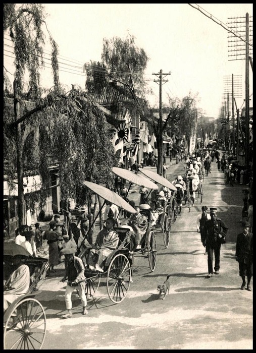К храму японского священника  в окружении слуг вез рикша, 1900 год.