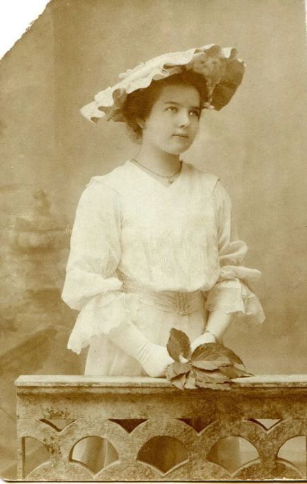 Модный образ девушки подчеркивает шляпка и белые перчатки.