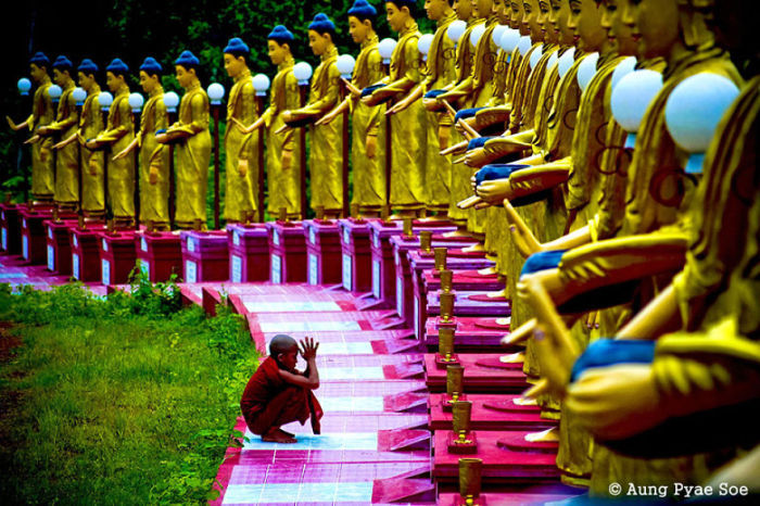 Буддистский молодой монах молится.