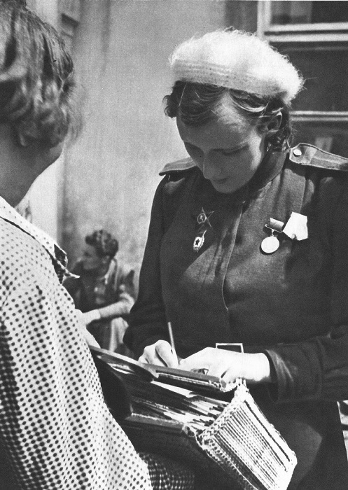 Советская девушка-военнослужащая оставляет автограф жительнице Праги.