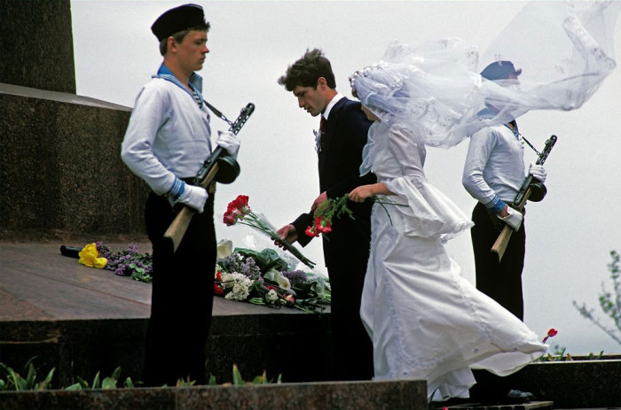 Молодожены возлагают цветы возле памятника героев.