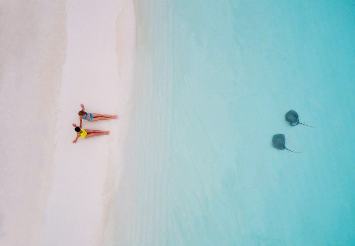 Девушки изображающие скатов на песке. Автор фотографии: tahitiflyshoot.