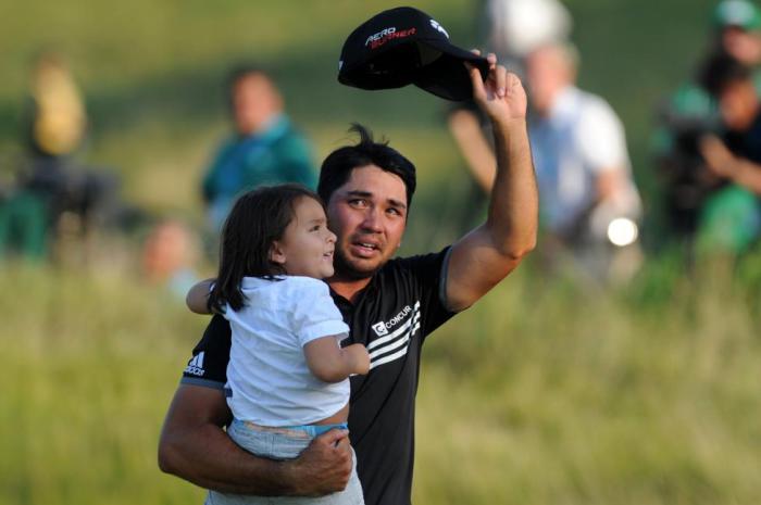 Гольфист со слезами на глазах и под бурные аплодисменты покидает дорожку № 18 со своим сыном после победы в чемпионате по гольфу PGA.