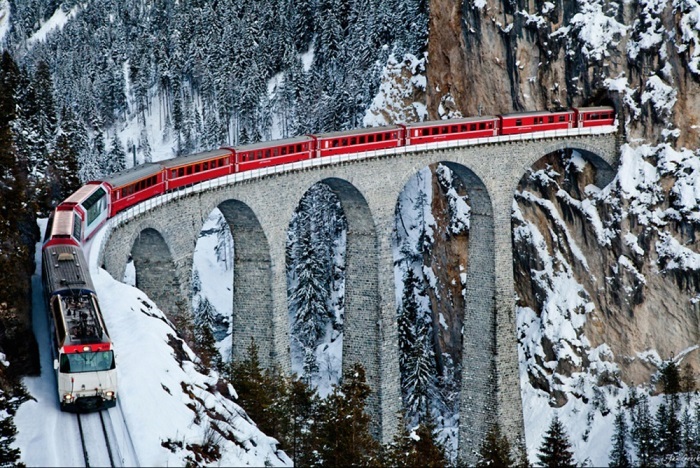 Арочный, каменный одноколейный железнодорожный виадук через реку Ландвассер в Альпах возле населенного пункта Филизур в кантоне Грисонс, Швейцария.