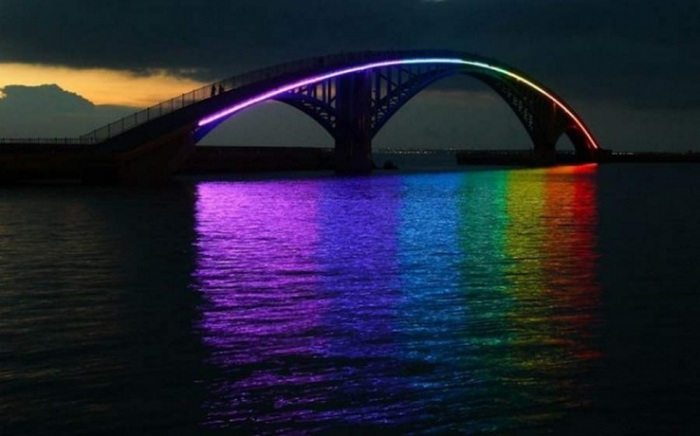 Конструкция представляет собой висячий мост, который полностью освещается всеми цветами радуги.