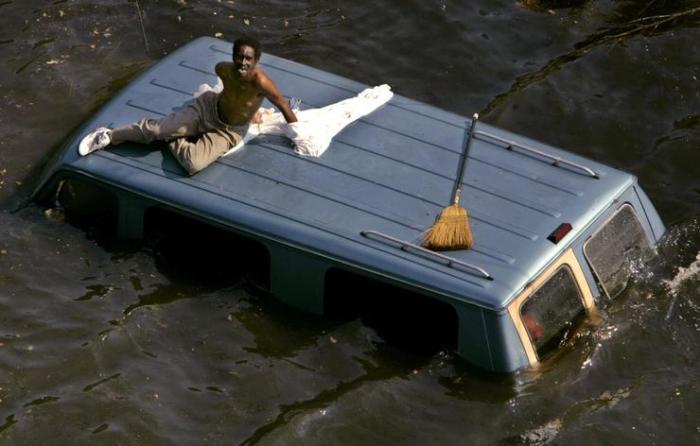 Мужчина лежит на крыше своего фургона, умоляя о помощи.