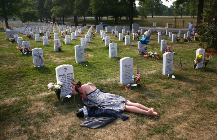 Жена солдата американской армии скорбит на его могиле.