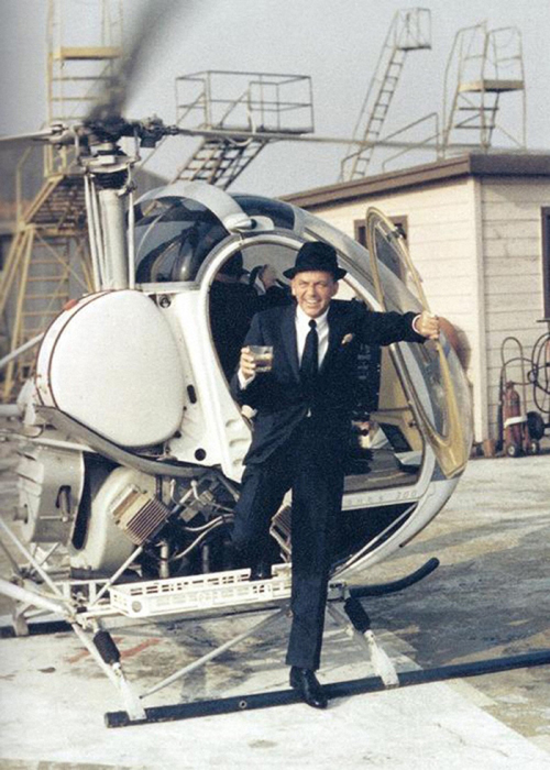 Фрэнк Синатра выходит из вертолета с напитком в руке.