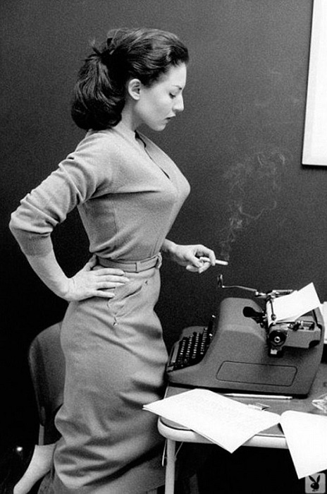 Красивая секретарша в облегающем платье с тонким ремешком на талии.