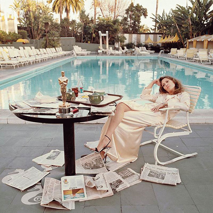 Фэй Данауэй завтракает у бассейна своего дома, просматривая свежую прессу, 1977 год.