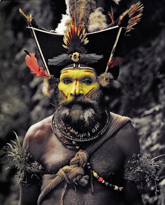 Мужчины Huli, раскрашивают свои лица в желтые, красные и белые цвета.