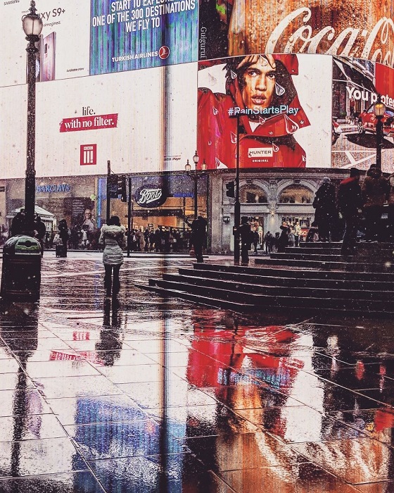 Поразительное отражение многолюдной улицы Лондона на мокром тротуаре.