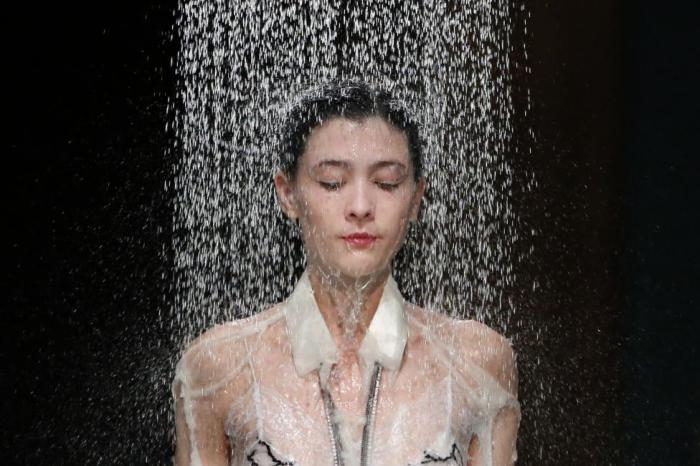 Девушка представляет коллекцию дизайнера Hussein Chalayan «Под дождём».