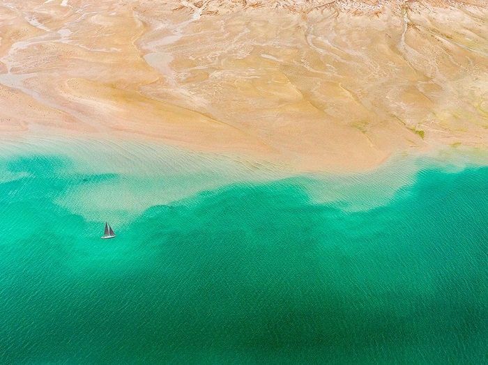 Сухая безжизненная пустыня встречается с изумрудным океаном. Фотограф - Abrar Mohsin.