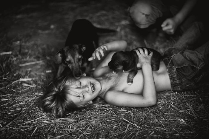 Черно-белое фото передает всю радость момента из жизни мальчика и животных.