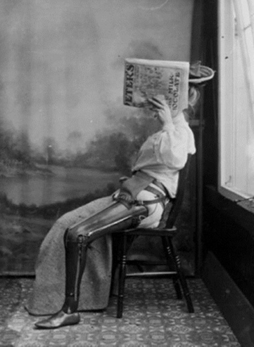 Женщина смущается своего протеза и прикрывает лицо газетой, 1890-1900 годы.