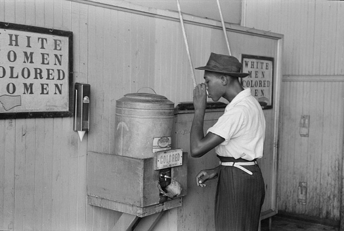 Чернокожий мужчина пьет воду из емкости, предназначенной только для белых, Оклахома-Сити, июль 1939 года.