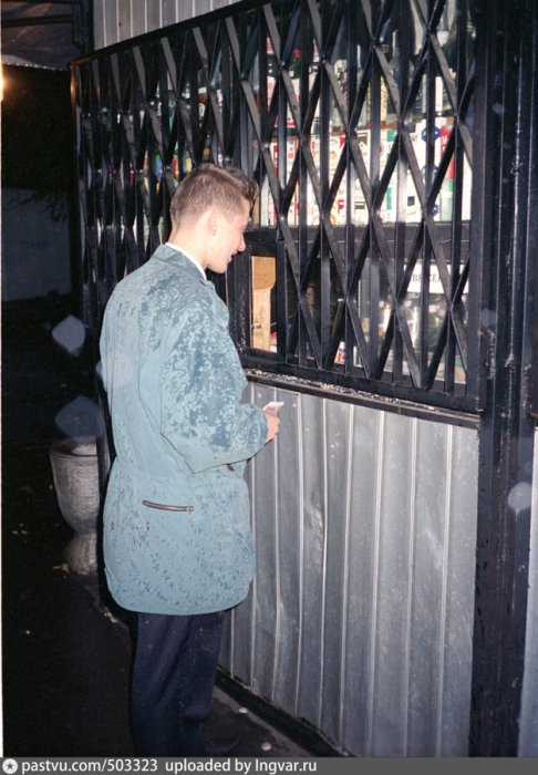 Мужчина покупает в ночном киоске спиртные напитки. Москва 1997 год.